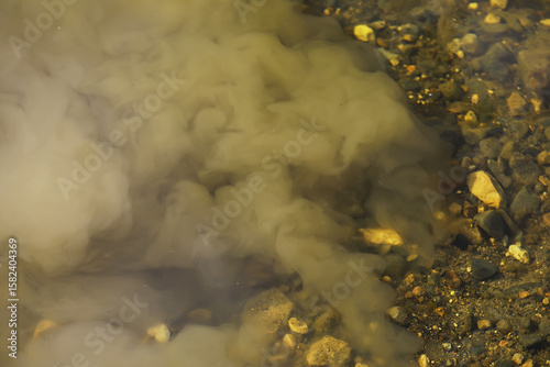 Muddy Water Mixing with River Rocks Underwater Close-up