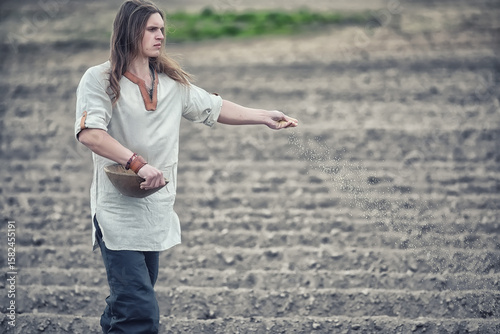 A young peasant sows the field with grain