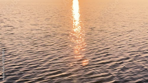 View of a Crystal clear water texture. Natural background. Ripple water reflection. Waves. Waves in motion with splashes	at sunset