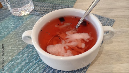 A refreshing iced drink made from young coconut, mixed with grass jelly and colorful jelly pieces. Served cold, it is a popular tropical beverage in Indonesia.