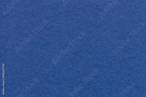 Texture of navy blue paper background with macro structure. Vintage dark denim cardboard backdrop closeup
