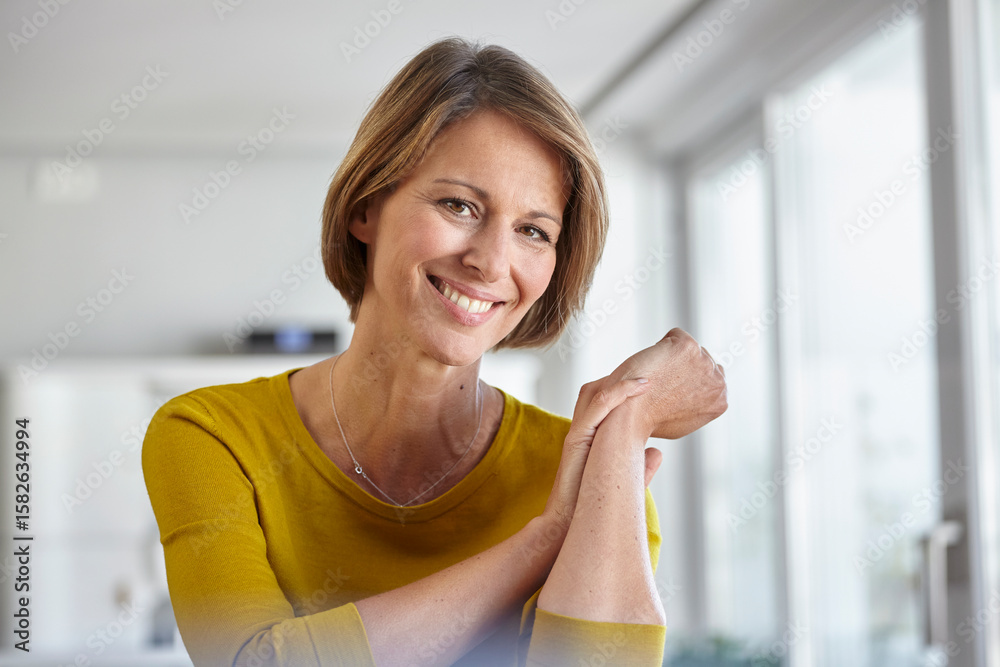 Smiling woman in a yellow sweater relaxing at home in a loft environment Smiling woman in a yellow sweater relaxing at home in a loft environment
