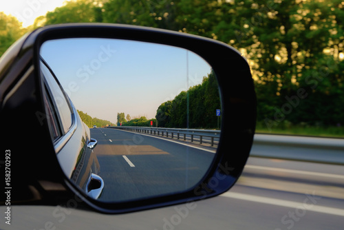 Look in the rear view mirror of a car. Car driving on the road