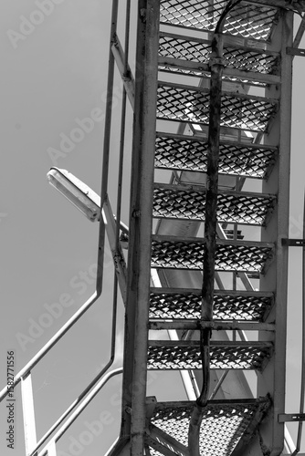 Sturdy metal ladder leads to heights against a clear sky, revealing a glimpse of adventure and exploration at midday