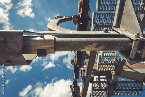 Elevating machinery against a backdrop of vibrant blue skies and fluffy clouds showcasing industrial engineering at its finest in mid-day light