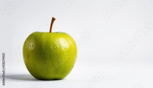 Fresh green apple with water droplets on a white background for health and wellness
