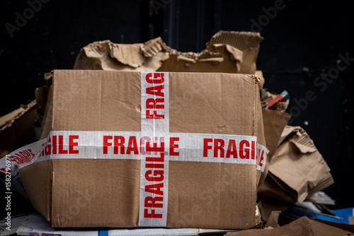 Cardboard boxes awaiting recycling collection on a street, with a shallow depth of field