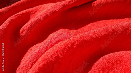 Red summer crinkled, wrinkled fabric for clothes. Red textile background. Red fabric.