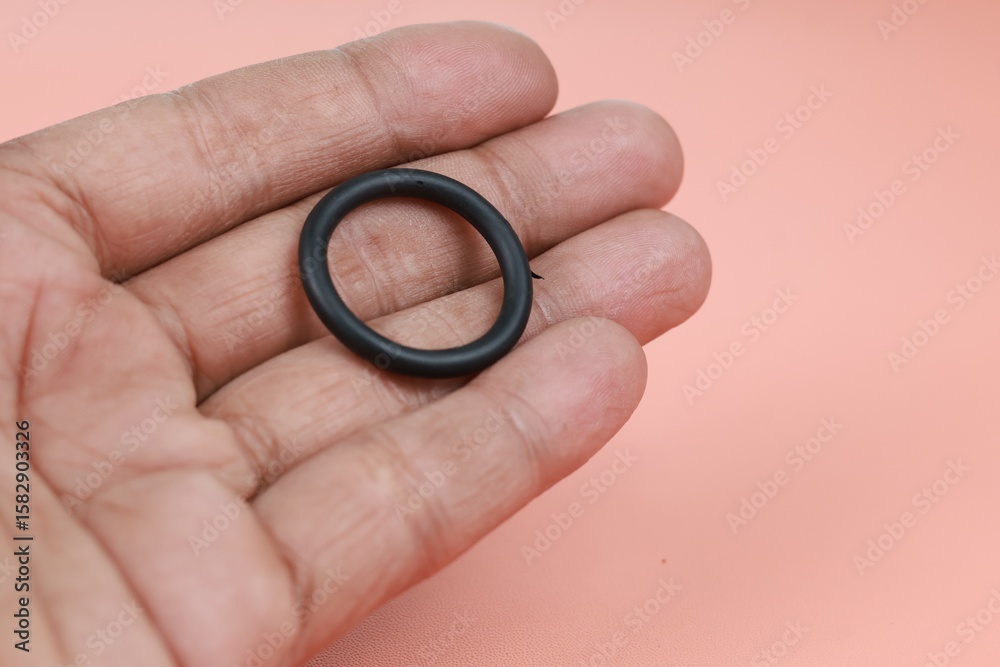 Close up Rubber O-ring lying on man hand for pneumatics and hydraulics isolate on brown background. Close up Rubber O-ring lying on man hand for pneumatics and hydraulics isolate on brown background.