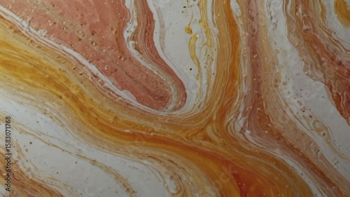 A colorful, flowing marble with curving and swirling patterns dominated by shades of orange, reddish brown, and creamy white. Small droplets or bubbles appear on the surface, providing an interesting 