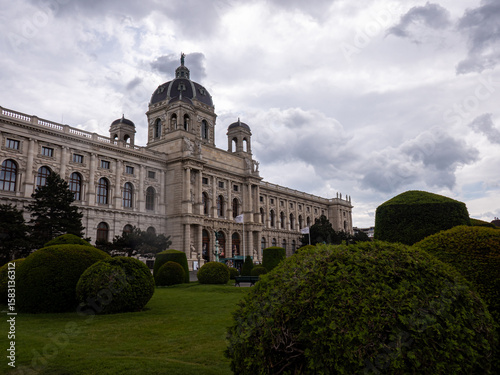 Canvas Print The Kunsthistorisches Museum in Vienna, Austria, surrounded by trimmed bushes and cloudy sky