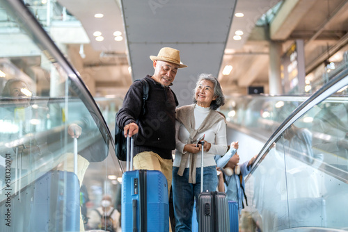 Senior asian traveler couple smiling at airport with suitcases show excitement before travel, retirement lifestyle, planning international journey, travel insurance for elderly, tour and global trip