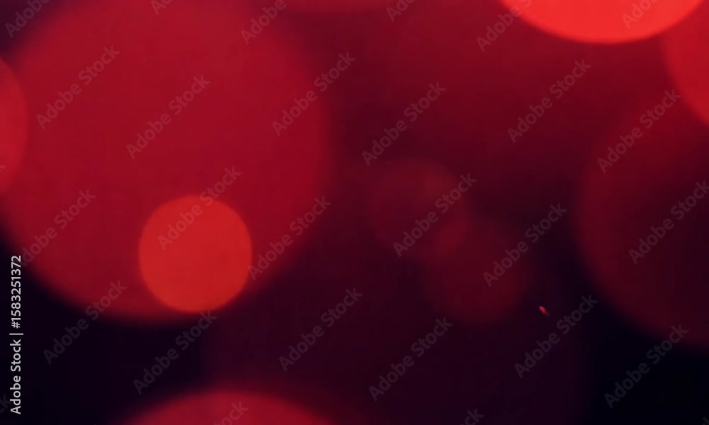 Upward motion of red bokeh light bubbles on dark background