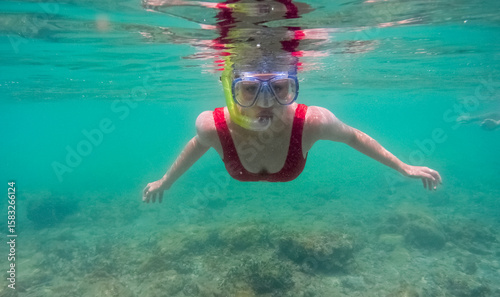 girl in red swimsuit underwater with snorkeling mask