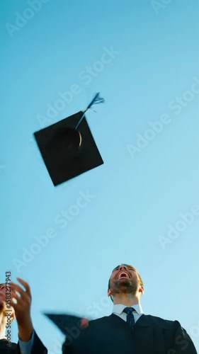 Diverse young graduates in black academic gowns joyfully toss caps into a clear blue sky, faces radiant with smiles in golden hour sunlight. Dynamic low-angle, crane, and POV videos. Concept of