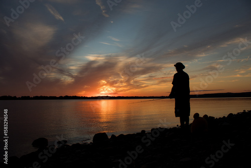 silhouette of man fishing at sunset