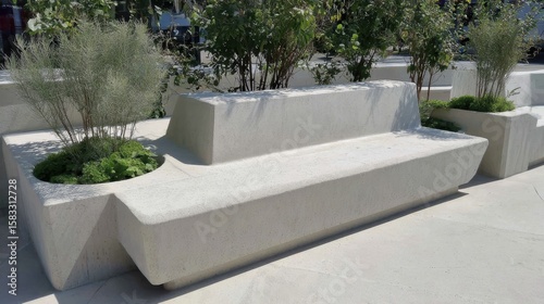 Fototapeta Naklejka Na Ścianę i Meble -  Sleek concrete seating nestled among verdant landscaping, providing relaxing points within modern urban green space design