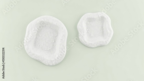Clean presentation of two white irregular shaped, sandy containers on a light background, showcasing design and texture