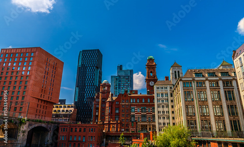 A panorama view over the River Medlock towards  buildings with contrasting architecture styles  in Manchester,UK in summertime

