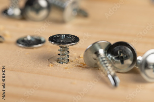 screw for fixing boards and other wood materials, self-tapping screws with a drill tip twisted into a board, closeup