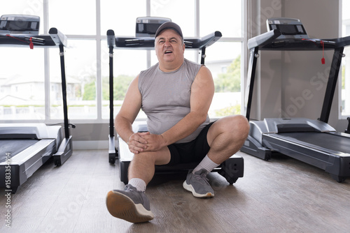 Exercise, knee pain, hands of man touching knee in gym. Male with injury after workout, training. Accident in gym. Knee injury at health club