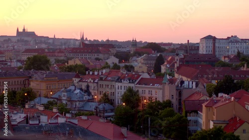 Aerial footage showcases a historic cityscape with picturesque rooftops, majestic churches, and charming buildings, all illuminated by a stunning sunset with vibrant colors