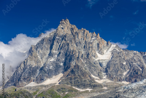Chamonix valley landscape of a prominent rocky towering mountain peak Aiguille du Midi in French Alps. Chamonix-Montblanc area, Tour du Montblanc beautiful landscape Aiguille du Midi summit, France