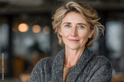 Happy elegant older mature lady posing for portrait standing in office. Beautiful middle aged business woman looking at camera, smiling 45 years old businesswoman leader executive at work.