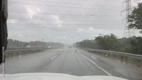 Driving on a highway with low visibility during a heavy rain event with windshield wipers going 