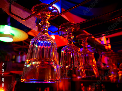 Cocktail and wine glass hanging over bar counter.