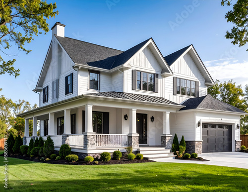A pristine white modern farmhouse stands proudly under a clear blue sky.
