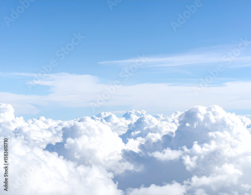 Majestic white clouds float peacefully across a vibrant blue sky, creating a serene and endless horizon.