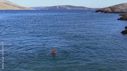 Beautiful Young Woman in Bikini Swims in Rt Skuljica Beach, Located on Hiking Trail Leading From the Beach in Baska to the Bag Mountain, Panoramic Aerial Shot Krk Island, Croatia. Mediterranean Summer