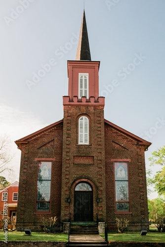Historic brick church with tall steeple.
