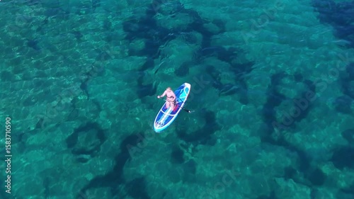 Beautiful Young Woman in Bikini Stand Up Paddling, Sup Surfing in Stara Baska Beach Krk Island, Croatia. Mediterranean Summer. Aerial Shot From Above. Blue Sea the Rocks  Mountains and Coastline