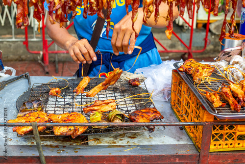Photography A street vendor grills marinated meat skewers over hot coals at a street food ca