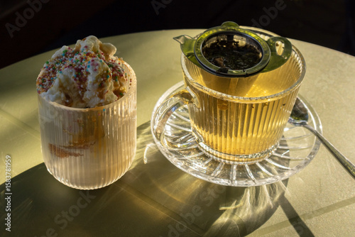 Warm Summer Tea and Iced Dessert on a Reflective Table