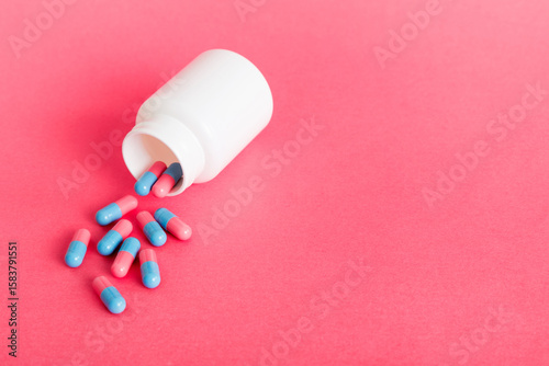 plastic medicine bottle with capsules of pills on colored background. Online pharmacy. Painkiller medicine and antibiotic drug resistance concept. Pharmaceutical industry