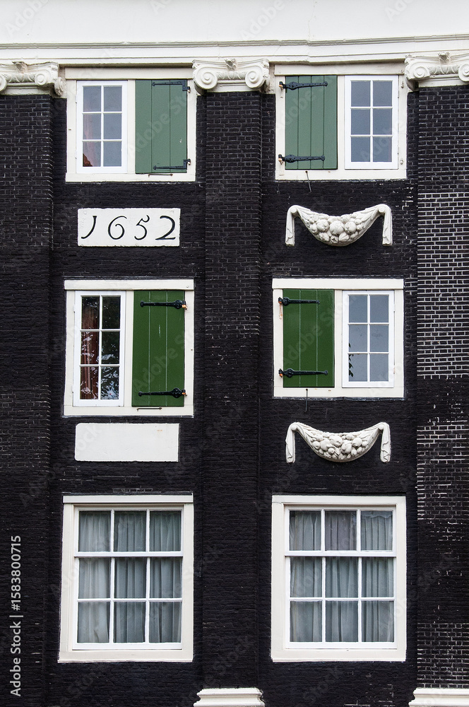 Obraz premium Closeup detail of colorful windows and shutters, a unique Dutch architectural feature on apartment buildings in Amsterdam, Holland, The Netherlands.