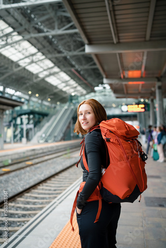 Young backpacker woman waiting at train station