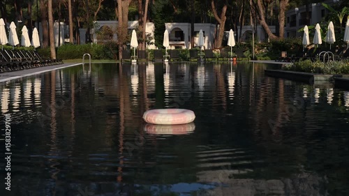 Pink hoop floating in an idyllic pool