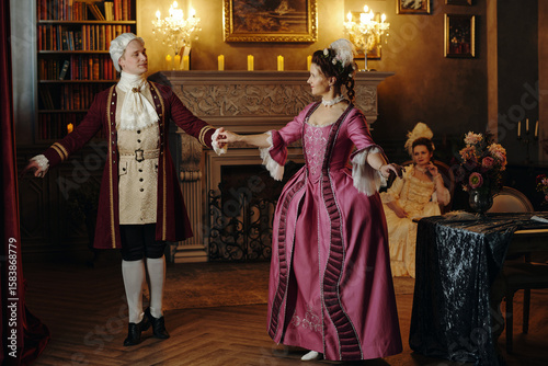 Obraz na plátně Caucasian middle aged man and woman wearing Baroque period costumes dancing toge
