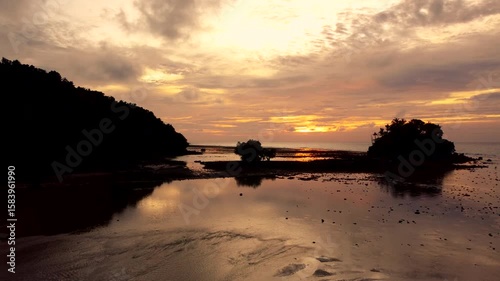 Colorful sunset above the sands beach and sea surface