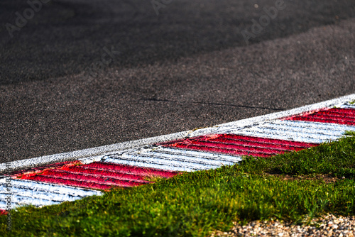 Obraz na plátně Close-up of a red and white rumble strip on a motorsport racing track