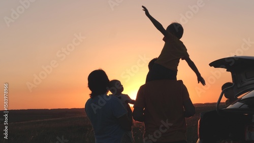 Konstfotografi happy family at sunset travel by car, mom dad and child on tourist trip by transport, family car of young couple, childhood dream, little child on dad shoulders fantasizes about flying, kid picnic