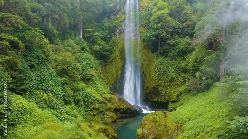 waterfall cascading in lush forest mist rising