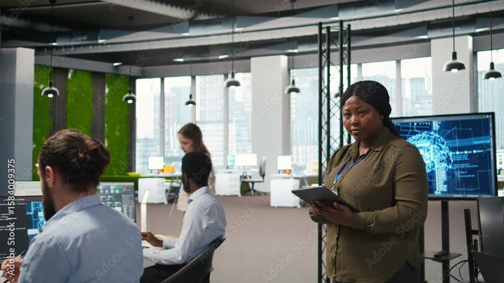 Happy female engineer in office automating repetitive tasks using AI scripts. Jolly african american developer using artificial intelligence to speed up feature implementation, camera A Happy female engineer in office automating repetitive tasks using AI scripts. Jolly african american developer using artificial intelligence to speed up feature implementation, camera A