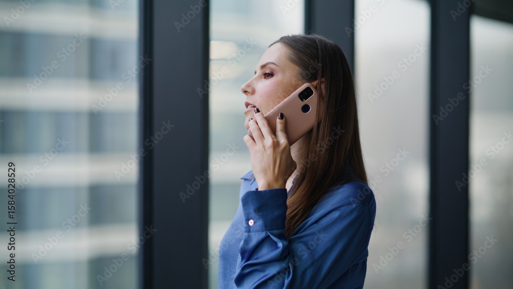 Professional manager consulting smartphone looking in office window closeup. Professional manager consulting smartphone looking in office window closeup.