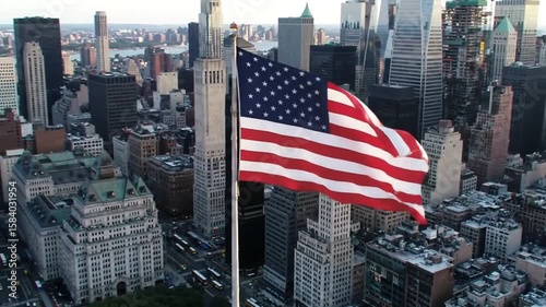 Aerial view of the american flag waving over a dense cityscape with tall buildings