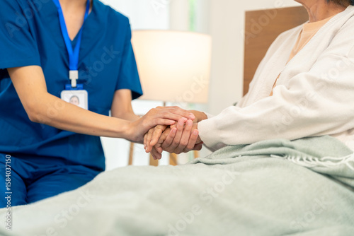 Foto Asian woman caregiver holding senior woman hands and consoling with empathy